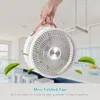 A hand holding a portable fan with green leaves floating around it, in a kitchen setting. Náhľad obrázku produktu
