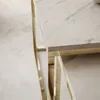 A close-up view of two nesting coffee tables with marble-effect tops and gold-colored metal frames, placed on a light-colored floor. Produktbild-Vorschau