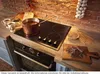 A kitchen scene with a stovetop, oven, and ingredients for making hot chocolate. Produktbild-Vorschau