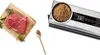 A raw piece of beef on a cutting board next to a wooden spoon with peppercorns and a food vacuum sealer. Náhľad obrázku produktu