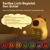 A cute capybara-shaped alarm clock with a digital display and colorful lights, shown with instructional text and examples of its different light modes. Produktbild-Vorschau