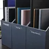 Three dark gray file organizers are shown, each containing various files and notebooks. Labels are visible on the front of each organizer: 'Travel', 'Home', and 'Insurance'. Produktbild-Vorschau
