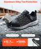 A pair of black VEVOR safety sneakers on a gravel surface with construction equipment in the background. Produktbild-Vorschau