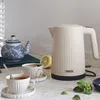 A cream-colored Princess kettle is shown on a kitchen counter with two cups of tea, a teapot, and a lemon. Náhľad obrázku produktu