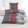 A bed with a plaid duvet and pillow in a room. Produktbild-Vorschau