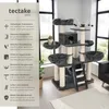 A multi-level cat tree with various platforms, hammocks, and scratching posts, set up indoors with natural light coming from windows in the background. Náhled obrázku produktu