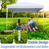 A family is having a picnic under a white pop-up canopy tent in a grassy park. Produktbild-Vorschau