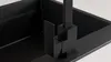 A close-up view of a black kitchen faucet installed in a black sink. Produktbild-Vorschau