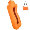 An orange inflatable lounger and a folded orange bag with a strap. Produktbild-Vorschau