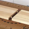 Two pieces of wood with dowels inserted, resting on a workbench with measurement markings. Anteprima dell’immagine prodotto