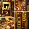 A collage of four detailed close-up images of a miniature book nook diorama, showcasing intricate details of a room with a fireplace, a study area with a gramophone and a cat, and a hallway with a grandfather clock and stairs. Voir les images du produit