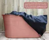 A pink Bath Bucket XL covered with a black tarp, set against a wooden plank background. Podgląd zdjęcia produktu