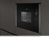 A built-in black microwave oven integrated into a dark gray kitchen cabinet. Náhľad obrázku produktu