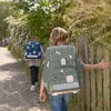 Two children walking on a path with backpacks. Voir les images du produit