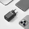 A black USB-C fast charger is shown on a white and light gray background, surrounded by parts of smartphones and a tablet. Produktbild-Vorschau