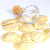 A close-up shot of homemade ravioli and a ravioli cutter. Produktbild-Vorschau