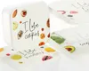 A set of square plastic food storage containers with lids, stacked on top of each other. The lids are decorated with images of food and text. Produktbild-Vorschau