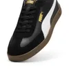 A close-up, angled view of a black Puma sneaker with a white stripe and gold branding. Voir les images du produit