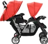 A tandem stroller with red canopies and black seats and frame, shown from the side against a white background. Náhled obrázku produktu