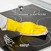 A hand wearing a yellow glove is cleaning a black glass ceramic hob with a pink cloth. The hob has circular heating zones marked on it. Text and logos are overlaid on the image. Produktbild-Vorschau