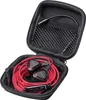 A pair of red wired earphones and their accessories are neatly organized inside an open black carrying case. Produktbild-Vorschau
