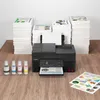 A Canon PIXMA G4570 printer is shown on a wooden desk, surrounded by stacks of paper and ink bottles. Produktbild-Vorschau