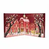 An open advent calendar depicting a festive winter street scene with houses, trees, and people. Produktbild-Vorschau