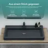 A dark gray rectangular washbasin with a black faucet is shown on a wooden surface, with text and icons displayed in a mirror reflection above. Produktbild-Vorschau