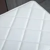 A close-up view of a white quilted surface. Náhľad obrázku produktu