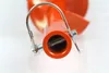 Close-up view of the end of an orange auger attachment with a metal pin and loop. Anteprima dell’immagine prodotto