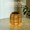 A rattan solar lantern is placed on a table, casting patterned shadows. Anteprima dell’immagine prodotto