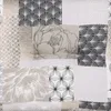 A collage of different fabric patterns, featuring floral and geometric designs in shades of gray and white. Produktbild-Vorschau