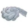 A braided pillow, also known as a knot pillow or snake pillow, is shown against a white background. Voir les images du produit