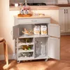 A kitchen cart with various items on and inside it, including bottles, pasta, glasses, and wine bottles. Voir les images du produit