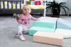 A baby is playing with soft foam climbing blocks in a nursery or playroom. Podgląd zdjęcia produktu