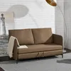 A brown sofa with a throw blanket draped over the armrest, placed in a room with a white brick wall and a floor lamp. Produktbild-Vorschau