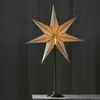 A star-shaped lamp on a stand against a dark background. Podgląd zdjęcia produktu