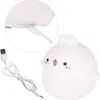 A white, cartoon-like rabbit night light with a USB charging cable. Produktbild-Vorschau