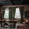 A rustic-style room with exposed brick walls, large windows, and a wooden table, featuring green velvet curtains. Voir les images du produit