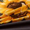 A close-up view of a fabric with a sunflower pattern and a dark gray fabric underneath. Anteprima dell’immagine prodotto