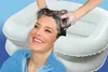 A woman is having her hair washed in an inflatable basin. Produktbild-Vorschau