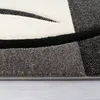 A close-up view of a textured rug with geometric patterns in black, white, and gray. Anteprima dell’immagine prodotto