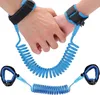 Two hands, one adult and one child, are connected by a blue coiled wrist strap. Náhľad obrázku produktu