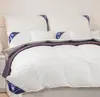 A neatly made bed with white pillows and a white duvet with a purple accent. Produktbild-Vorschau