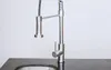 A close-up shot of a modern kitchen faucet with a pull-down sprayer, mounted on a dark countertop above a sink. Produktbild-Vorschau
