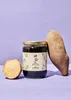 A jar of yacon syrup is displayed with two yacon roots, one whole and one cut in half, against a purple background. Produktbild-Vorschau
