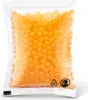 A clear, well-lit studio shot of a sealed plastic package filled with small, orange, spherical beads. Voir les images du produit