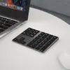 A wireless numeric keypad is placed on a white table next to a laptop. Produktbild-Vorschau