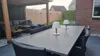 An outdoor patio with a dining table and chairs, and a lounge area under a pergola. Produktbild-Vorschau