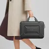 A person is holding a black laptop bag. Náhled obrázku produktu